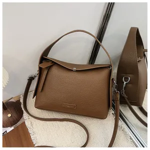 Detailed view of the brown lychee grain texture on a stylish women's crossbody square bag