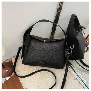 Detailed view of black lychee grain texture on versatile women's crossbody handbag