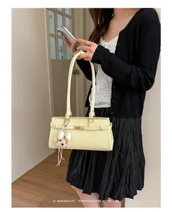 Minimalist pale yellow underarm tote bag with cute bear charm detail