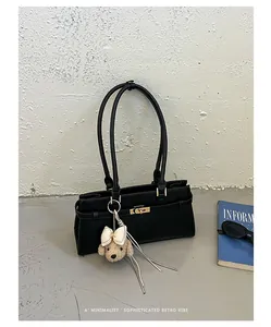 Black minimalist tote bag with cute poodle charm and retro vibe detail.