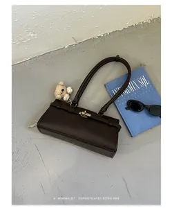 Minimalist dark brown leather underarm bag with long straps and small bear charm