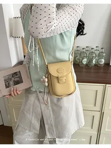 Lifestyle shot of a model wearing a vintage yellow pebbled leather crossbody saddle bag.
