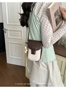Elegant vintage style canvas and leather saddle bag for women shown on a model.