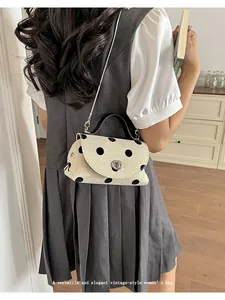 Lifestyle weergave van een vintage mini crossbodytas met stippen en zilveren ketting
