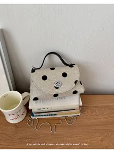Elegante vintage polkadot handtas met zilveren kettingriem en zwart handvat bovenop