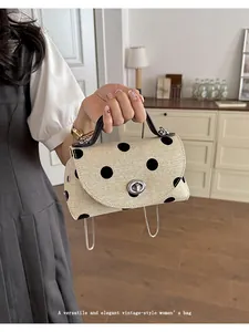 Close-up van het elegante zwarte stippenpatroon op een beige vintage mini-handtas