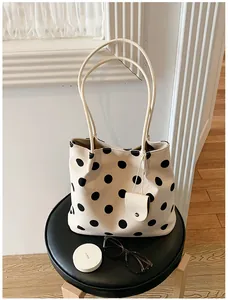 Elegante bolso tote blanco con lunares negros de gran capacidad en un entorno de estilo