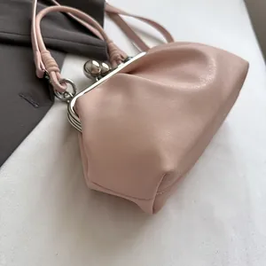 Detailed view of elegant pink ruched handbag with silver ball kiss-lock metal frame