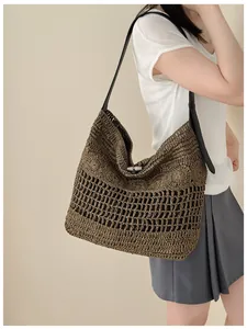 Gros plan d'un mannequin portant un sac de plage tissé marron avec bandoulière noire