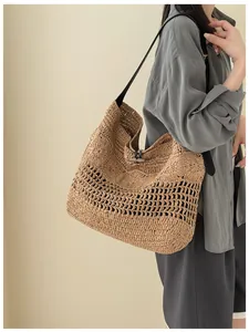 Vue détaillée du grand sac à bandoulière en paille tressée ajourée pour la plage d'été.