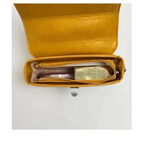 Vista interna dettagliata della borsa retrò gialla con scomparto e tasca con zip