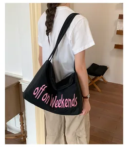 Casual black nylon tote bag with pink 'off on weekends' embroidery shown on model