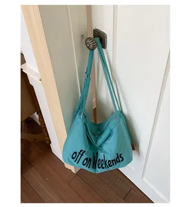 Lightweight teal nylon tote bag hanging on a door handle in a stylish home setting.