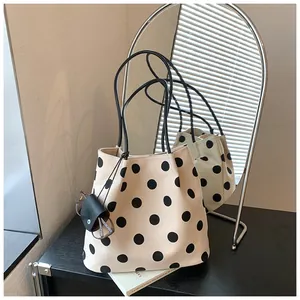 Detalle de bolso tote de lunares con funda para gafas en un entorno de estilo de vida.