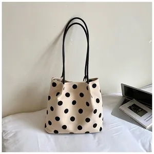 Bolso tote de lona con lunares de gran capacidad en un entorno de oficina minimalista