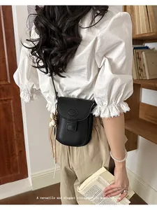 Elegant black vintage-style women's crossbody saddle bag shown in a cozy library setting.