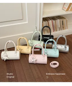 Detailed view of woven cylinder handbags in multiple pastel colors with star charms