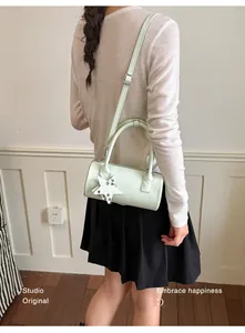 Woven mint green cylinder crossbody bag shown on model for a trendy fashion look