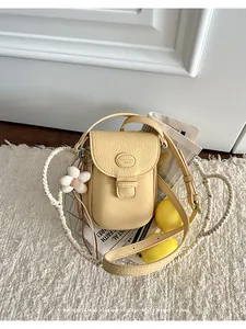 Detailed view of a vintage cream yellow pebbled leather crossbody bag in a basket