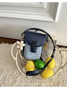 Vintage denim and navy PU saddle bag styled in a wire basket with fresh lemons and lime.