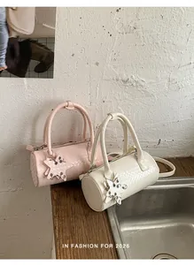 Close-up view of stylish woven pillow bags in pink and cream with star charms
