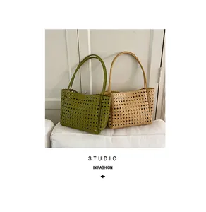 Detailed view of two woven hollow-out tote bags in green and tan colors for daily use