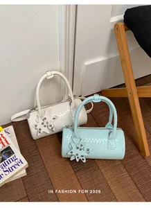 Detail of woven pillow handbags in white and blue with star charms on wood floor