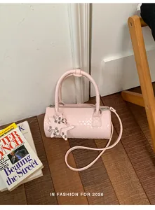 Chic pink woven pillow bag featuring a star charm detail on a natural wooden floor