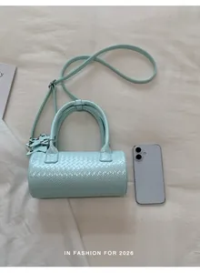 Chic mint green woven barrel bag shown alongside a smartphone for scale reference