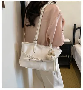 Élégant sac cabas blanc avec bandoulières réglables et breloque ours sur un mannequin