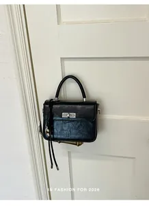 Borsa a mano vintage nera con trama in finta pelle stropicciata appesa a una porta