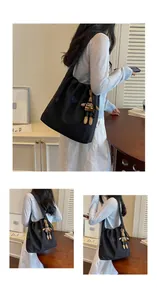 Black nylon tote bag styled on model in casual indoor setting