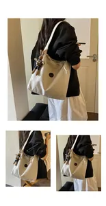 Model wearing a lightweight nylon tote bag with drawstring and bunny charm detail.