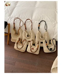Handmade woven straw tote bags in various sizes featuring wooden bead strap details.