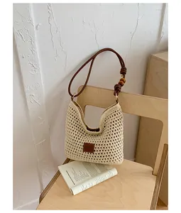 Detail view of handmade woven straw tote bag on a wooden chair for beach vacation