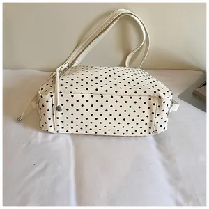 Detailseitenansicht einer großen weißen Polka-Dot-Tasche mit zwei Schultergurten