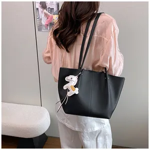 Elegant black pebbled leather commuter tote bag featuring a cute horse charm on shoulder
