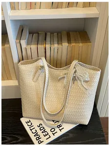 Sac cabas tissé crème élégant avec nœud en dentelle perlée dans une bibliothèque