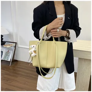 Detailed view of elegant pale yellow leather tote bag featuring a charming white horse