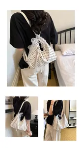 Detailansicht eines gepunkteten Rucksacks mit Spitzenschleife und Perlenanhängern im Schlafzimmer