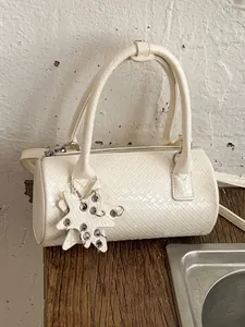 Elegant white woven pillow handbag for women featuring a stylish star charm accessory