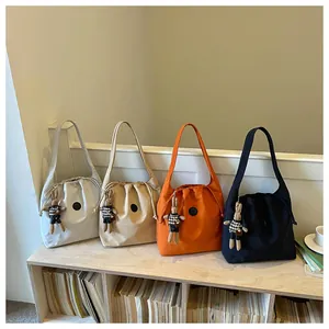 Detailed view of four colorful lightweight nylon shoulder bags with cute rabbit charms