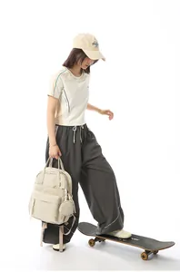 Stylish cream-white student backpack shown in a lifestyle pose with a skateboard