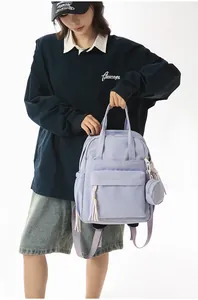 Close-up of a stylish lavender purple backpack held by a model in a casual outfit.