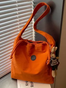 Stylish orange nylon drawstring bucket bag with a cute rabbit charm for daily commute