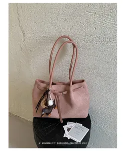Detailed view of pink commuter tote bag with dog charm on black stool