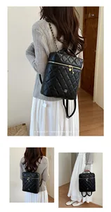 Vista dettagliata dello zaino nero trapuntato con catena su modella con stile rétro