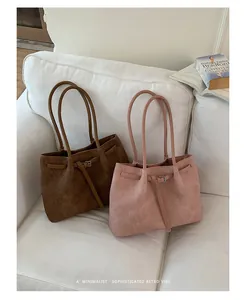 Detailed view of two minimalist textured tote bags in pink and brown on white sofa