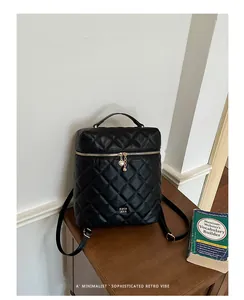 Zaino nero trapuntato con cerniera a cuore dorata in un'ambientazione rétro chic.