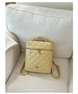 Dettaglio dello zaino trapuntato da donna color crema con ciondolo a cuore minimalista